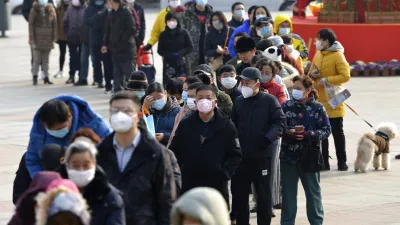 武漢肺炎疫情肆虐,首架武漢台商包機4日凌晨返抵國門。圖為南京民眾正在排隊搶購口罩。(資料照,美聯社)