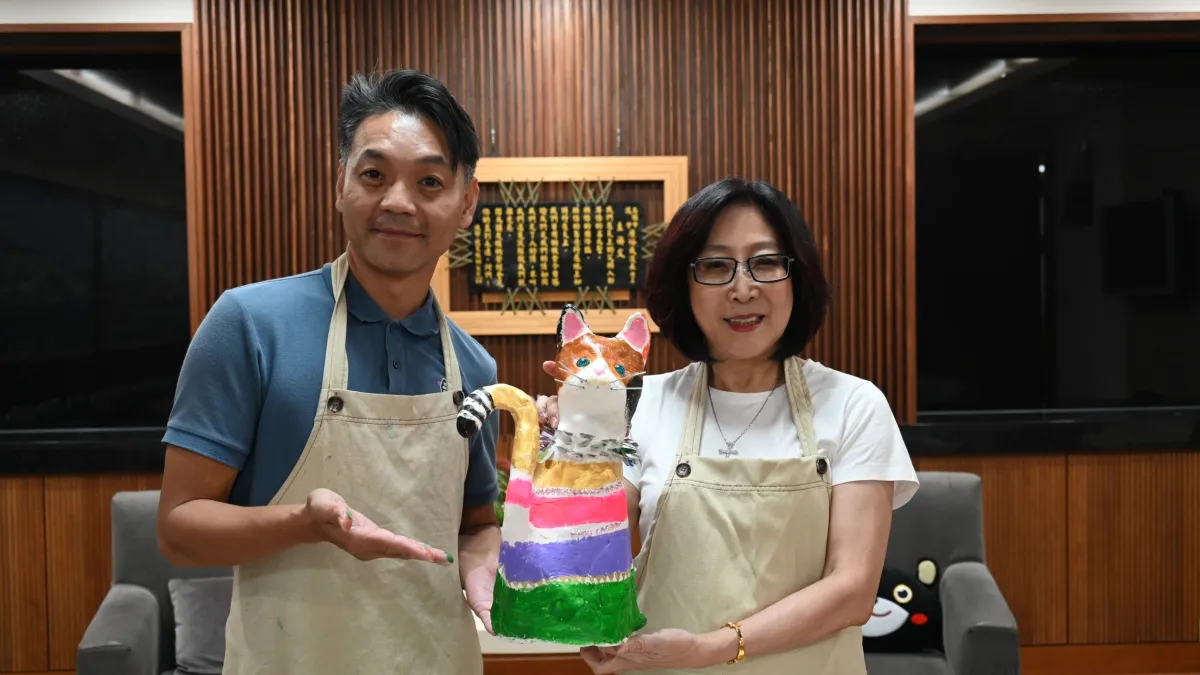 議長康裕成(右)為貓咪裸雕「穿新衫」,與豐裕里長謝錫彩繪貓咪。(圖/高雄市議會提供)