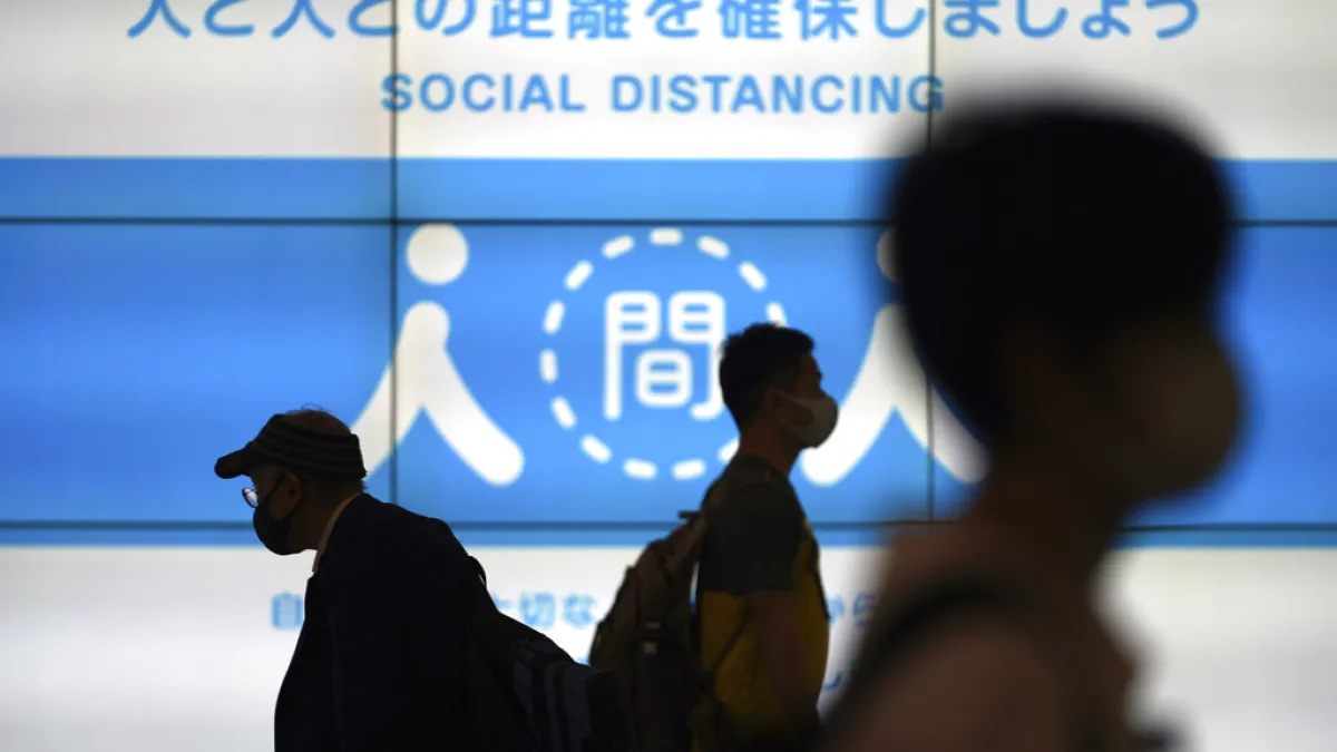 東京街頭宣導保持社交距離的巨幅廣告。(美聯社)