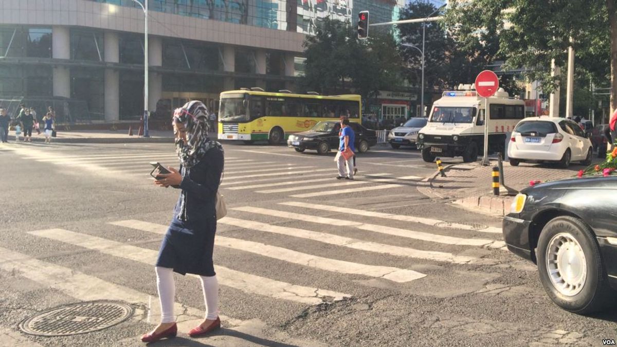 烏魯木齊街頭有婦女邊走邊看手機。(美國之音) 烏魯木齊街頭有婦女邊走邊看手機。(美國之音)