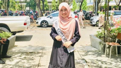 Nasyiratu wears a sash after winning a prize