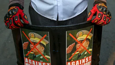 2021年3月,緬甸曼德勒省的反政變示威者手舉軍政府領導人敏昂萊肖像。(資料照,美聯社)