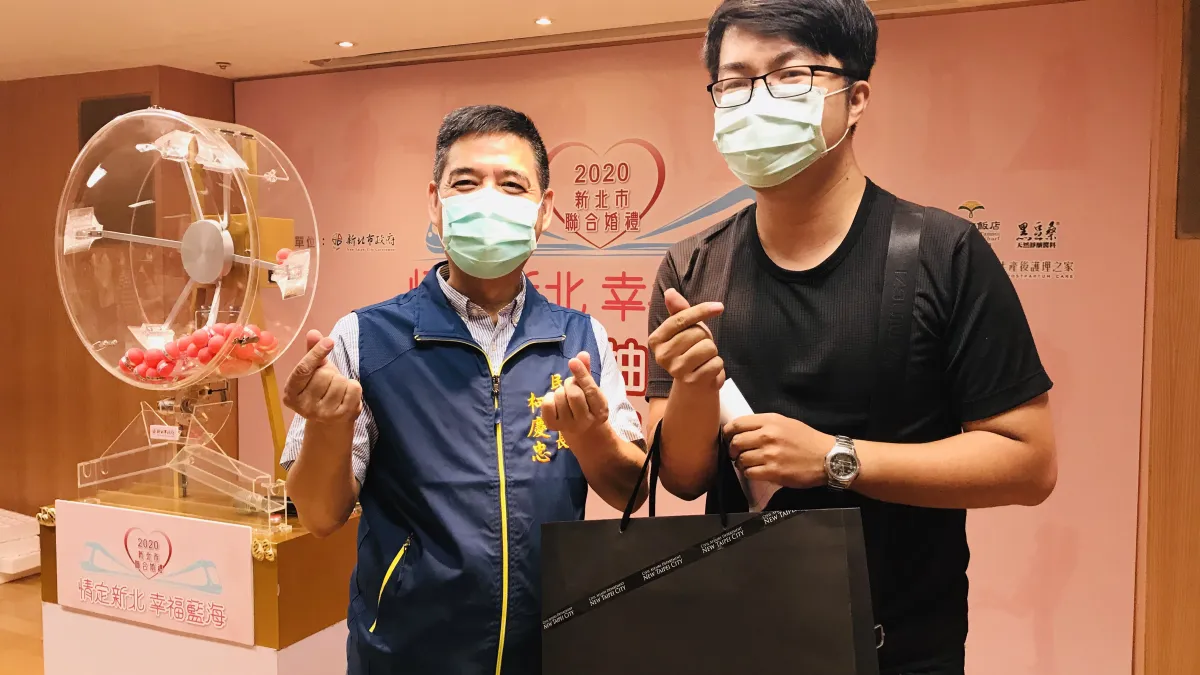 現場來觀禮的新人江先生,幸運抽中,開心與民政局長柯慶忠合影。(圖/新北市民政局提供)