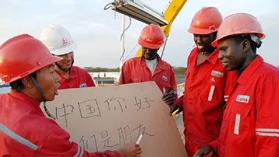 2008年,在蘇丹一處油井,一位中國僱員教蘇丹工人讀中文:「中國你好,我們是朋友。」 HU QINGMING/IMAGINECHINA, VIA CORBIS