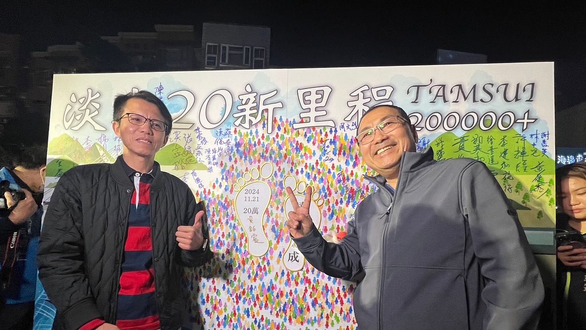 侯友宜與第20萬區民的父親一同在簽名牆上簽名留念。(圖/新北市民政局提供) 侯友宜與第20萬區民的父親一同在簽名牆上簽名留念。(圖/新北市民政局提供)