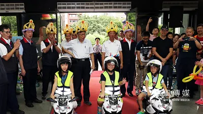 台北市警察局28日舉行親子日,上午的活動由3位小朋友,身著寫有警察字樣的反光背心,頭戴安全帽,站在縮小版的重機旁,列隊向台北市長柯文哲敬禮後,騎上小機車,引領市長和警察局長官進場揭開序幕。(蘇仲泓攝)