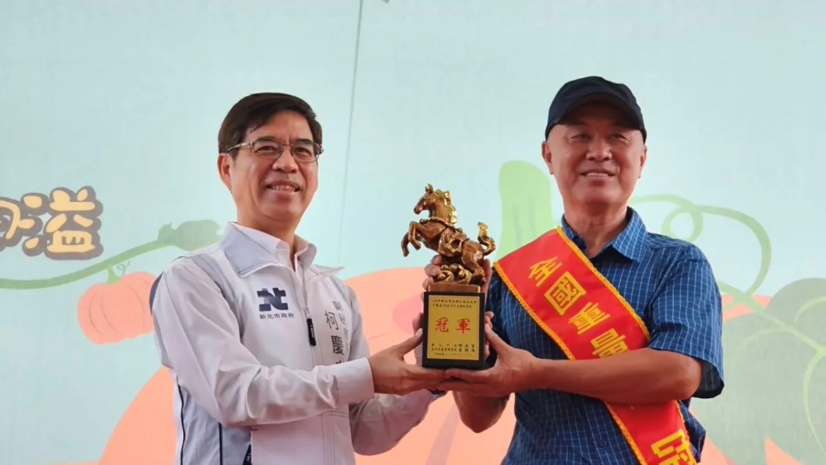 來自淡水區的農友林建訓(右)以重達773台斤的巨無霸南瓜勇奪重量組冠軍,也是第九度取得重量組冠軍頭銜,副秘書長柯慶忠(左)頒發獎座表揚。(圖/新北農業局)