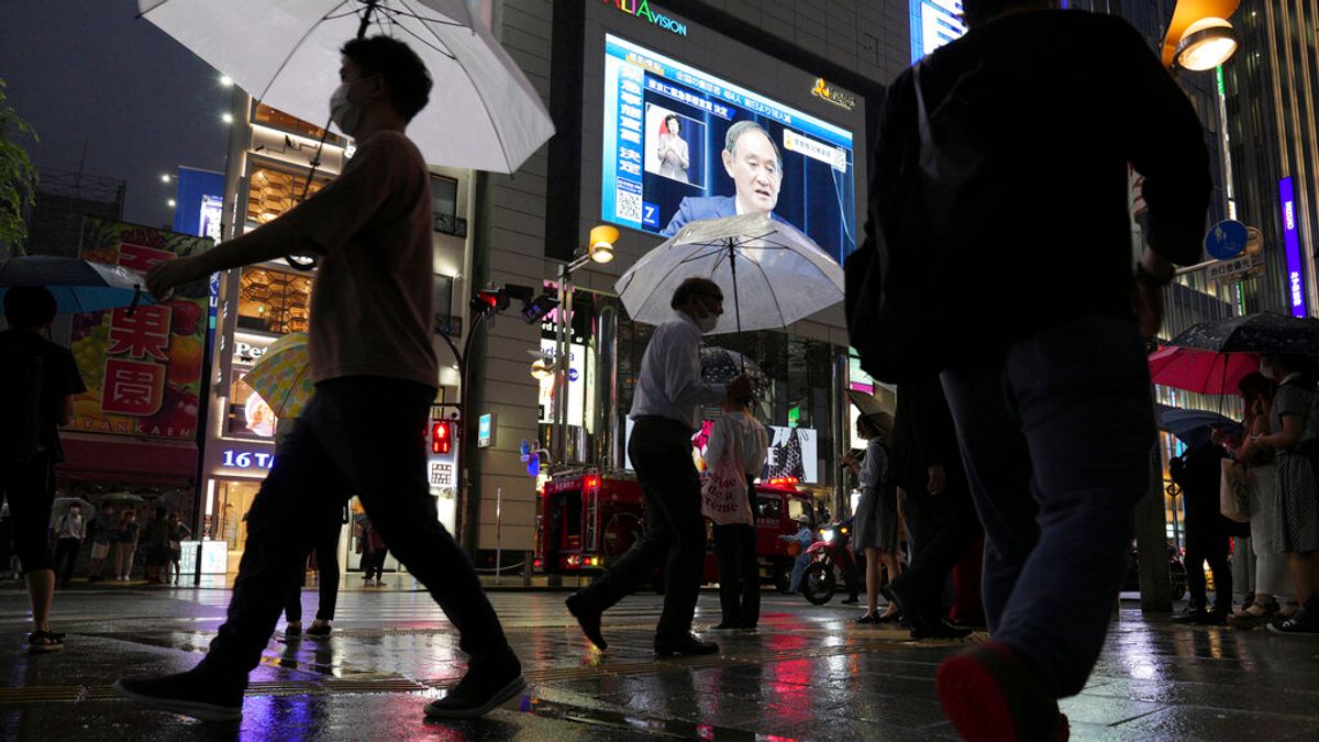 東京鬧區街頭的大螢幕上,正在播放菅義偉宣布東京將在7月12日進入第四波緊急事態的記者會。(美聯社) 東京鬧區街頭的大螢幕上,正在播放菅義偉宣布東京將在7月12日進入第四波緊急事態的記者會。(美聯社)