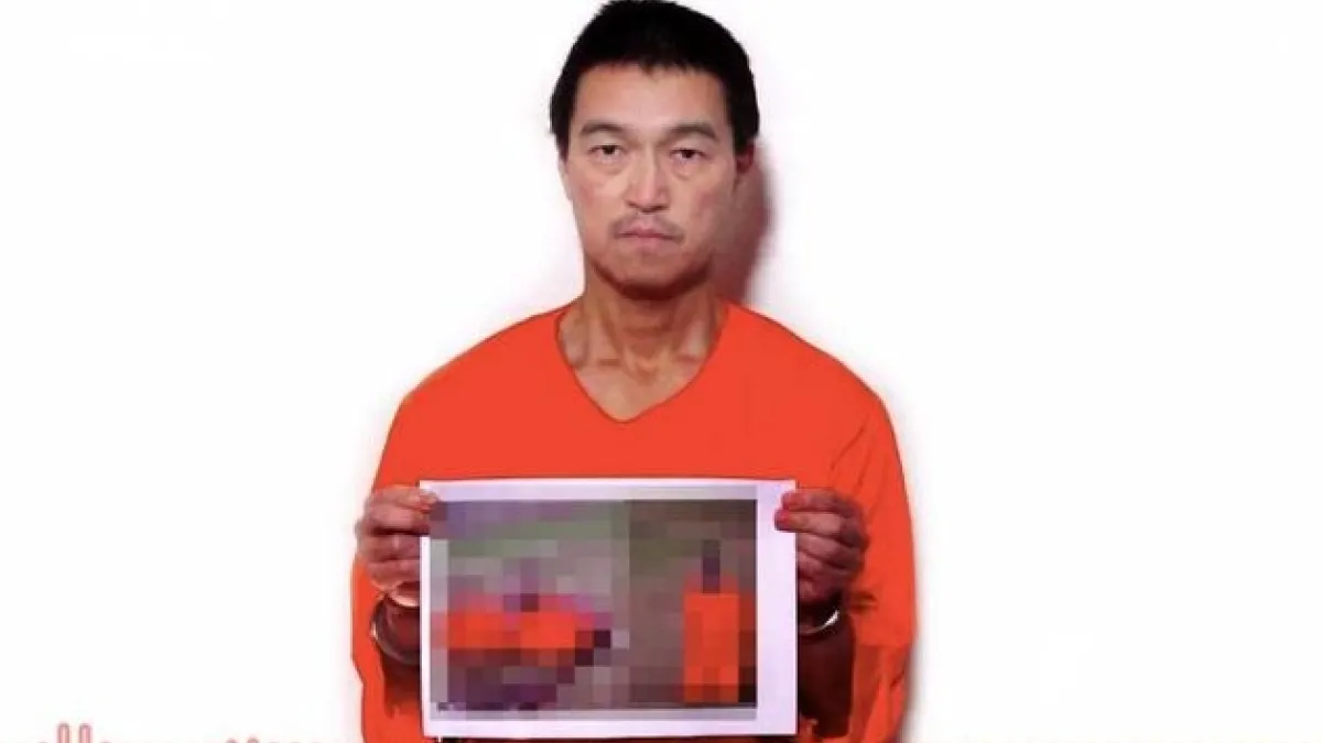 遭伊斯蘭國綁架的日本人質後藤健二,拿著同伴湯川遙菜遭到處決的照片。(取自網路)