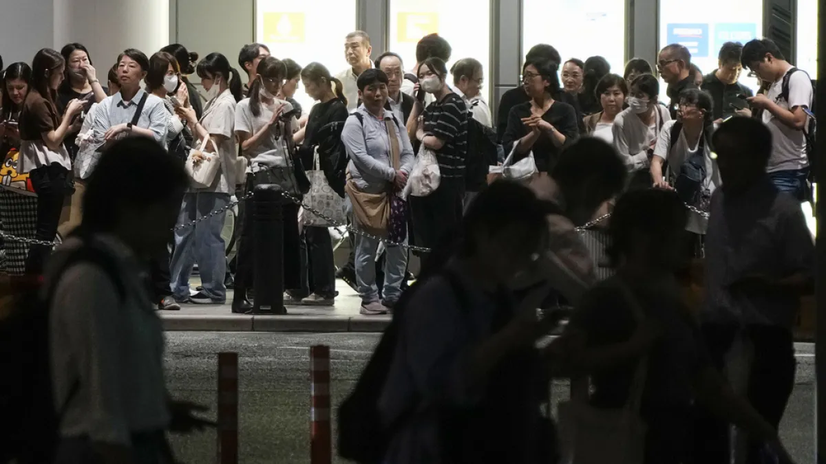 Illustrative file photo: People queue outside a building in Japan. Foreign residents have been crowding immigration bureaus nationwide ahead of the October 1 increase in residency fees. (AP))