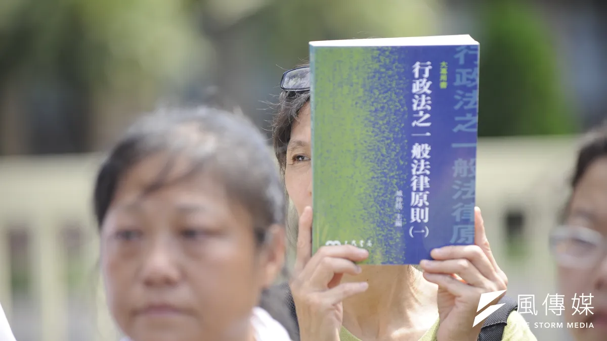 反南鐵東移自救會在行政院前舉辦記者會,並朗頌內政部長葉俊榮等公法學者著作。(甘岱民攝)