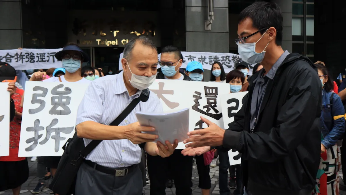 黎明清境社區住戶於14日赴市府陳情,由住戶代表葉承(左)遞交陳情書,市府方面由工務局總工程司蘇志民(右)代表接受。(圖/新北市工務局提供)