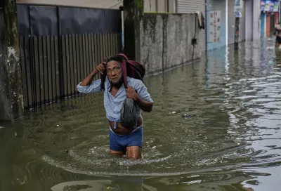 2025年11月29日,氣旋「迪特瓦」(Cyclone Ditwah)登陸斯里蘭卡,災情嚴重,首都可倫坡(Colombo)的災民拿著家當前往避難。(美聯社)
