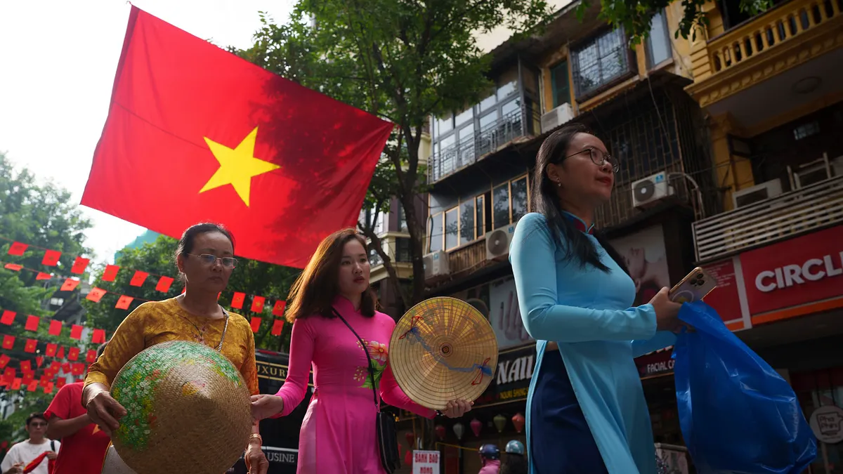 2025年9月1日,越南河內舊城區,越南女子身穿傳統服飾「奧黛」漫步街頭。(美聯社) 2025年9月1日,越南河內舊城區,越南女子身穿傳統服飾「奧黛」漫步街頭。(美聯社)
