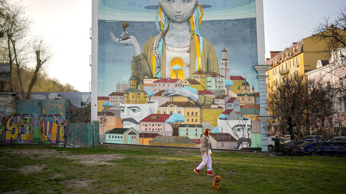 2024年4月1日,基輔一名烏克蘭婦女牽著一隻狗在壁畫前散步。(美聯社) 2024年4月1日,基輔一名烏克蘭婦女牽著一隻狗在壁畫前散步。(美聯社)