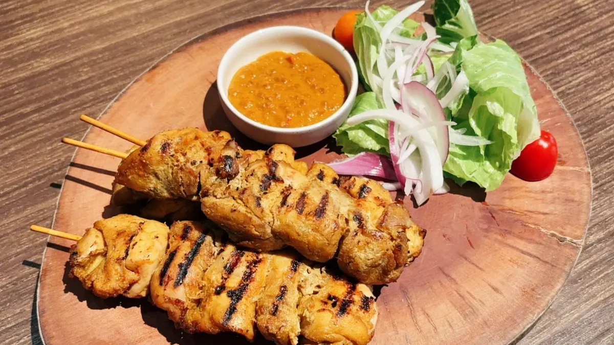 溫馨母親節六人分享餐包含「沙嗲雞肉大串串」,烤至表面微焦的雞肉搭配主廚特調沙嗲醬,份量十足的串燒每份有三串,是不容錯過的星馬經典街頭美食。(圖/天成文旅-華山町提供)