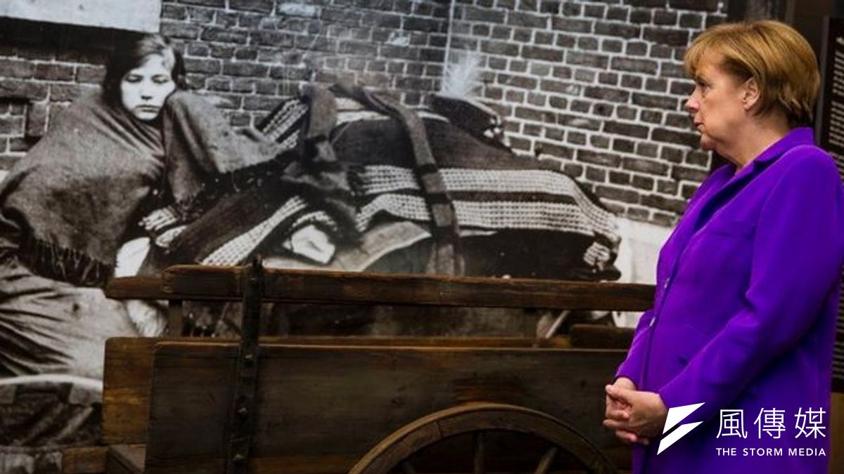 德國總理梅克爾在一戰特展中的比利時難民照片前方駐足。(美聯社) 德國總理梅克爾在一戰特展中的比利時難民照片前方駐足。(美聯社)