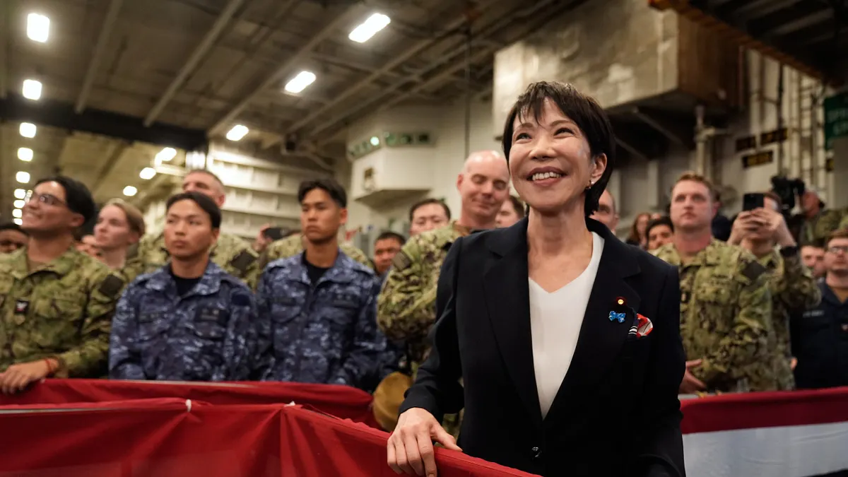 2025年10月28日、神奈川県横須賀基地の空母「ジョージ・ワシントン」上で、駐日米軍に向けたトランプ米大統領の演説を傍聴する高市早苗首相。(AP通信) 2025年10月28日、神奈川県横須賀基地の空母「ジョージ・ワシントン」上で、駐日米軍に向けたトランプ米大統領の演説を傍聴する高市早苗首相。(AP通信)