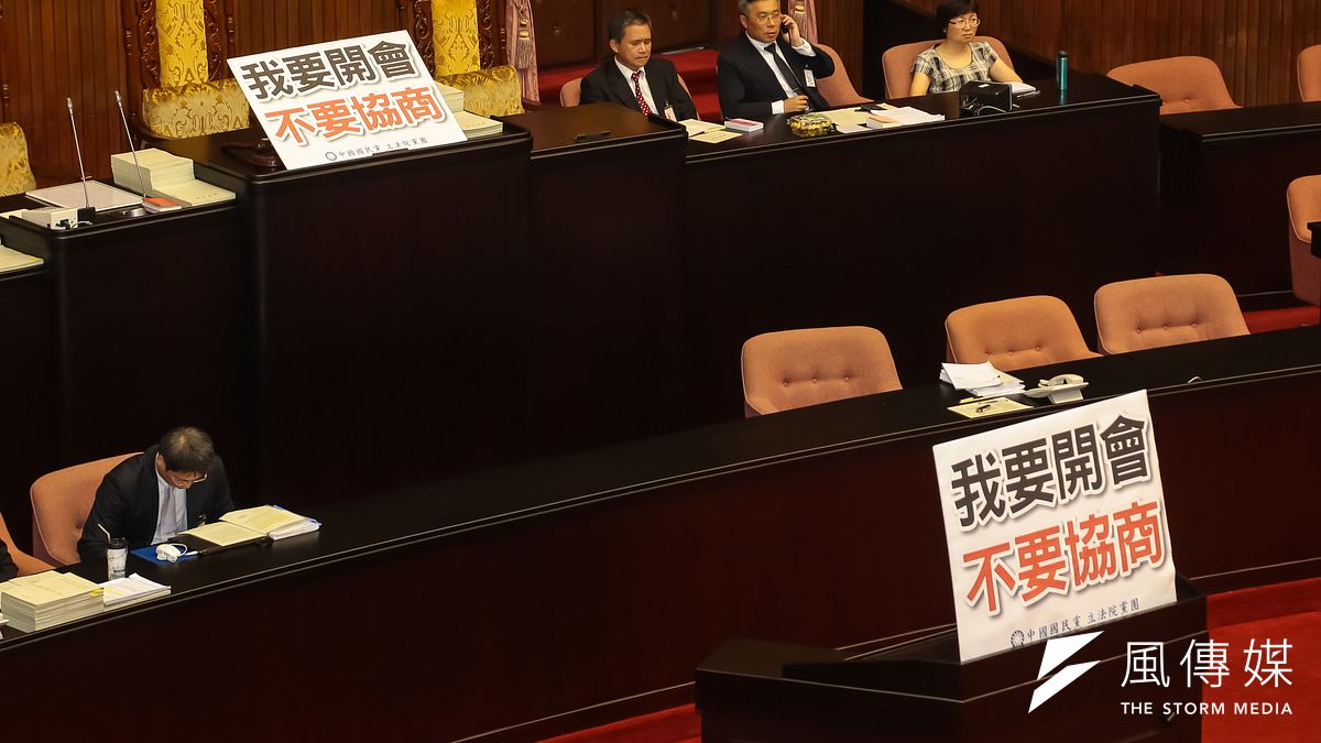 蘇嘉全宣布休息協商後,國民黨委員於主席台及發言台擺上「我要開會,不要協商」標語。(顏麟宇攝) 蘇嘉全宣布休息協商後,國民黨委員於主席台及發言台擺上「我要開會,不要協商」標語。(顏麟宇攝)