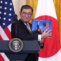 米関税交渉で譲歩を拒む石破茂首相。写真は今年2月、訪米中にホワイトハウスで行われた記者会見で、トランプ大統領に関する書籍を手にする様子。(AP通信) 米関税交渉で譲歩を拒む石破茂首相。写真は今年2月、訪米中にホワイトハウスで行われた記者会見で、トランプ大統領に関する書籍を手にする様子。(AP通信)