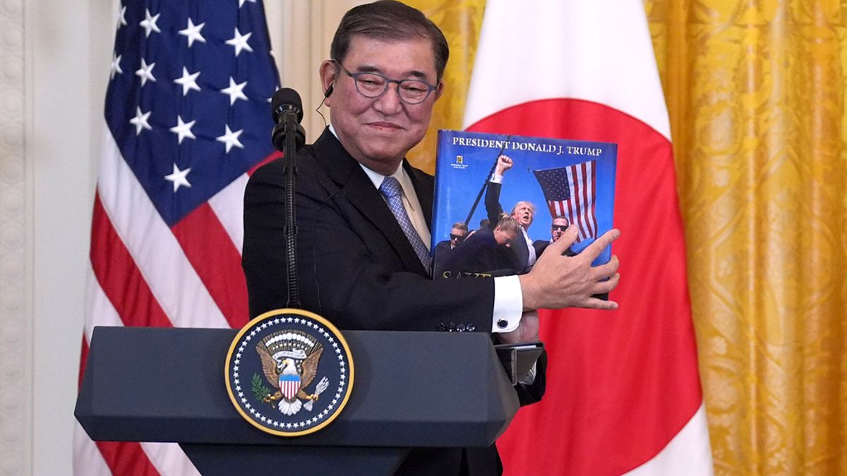 米関税交渉で譲歩を拒む石破茂首相。写真は今年2月、訪米中にホワイトハウスで行われた記者会見で、トランプ大統領に関する書籍を手にする様子。(AP通信) 米関税交渉で譲歩を拒む石破茂首相。写真は今年2月、訪米中にホワイトハウスで行われた記者会見で、トランプ大統領に関する書籍を手にする様子。(AP通信)