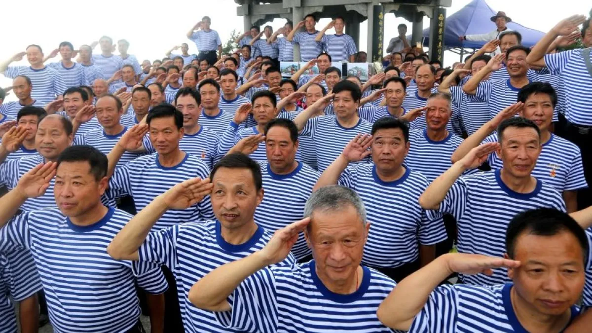 分析人士認為,屢次發生的老兵維權是伴隨著中國改革開放和軍隊改革形成的「歷史遺留問題」(資料照,2017年建軍節前,老兵在河南洛陽向中國國旗敬禮)(BBC中文網)