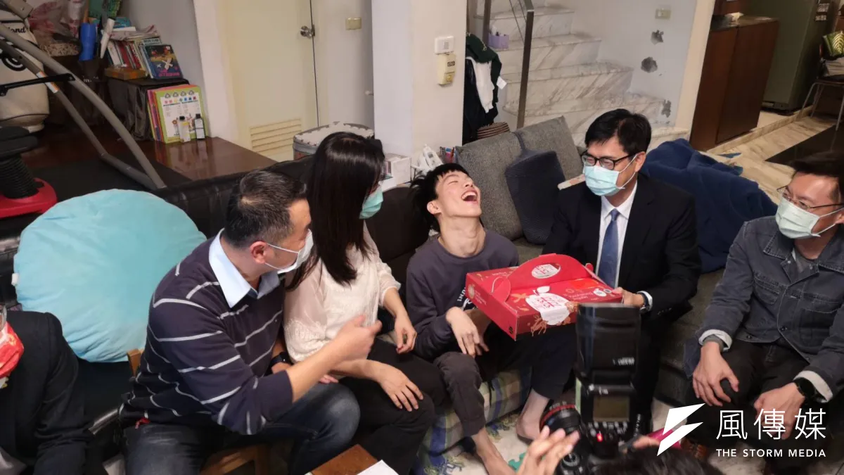 陳其邁市長探訪腦麻青年蔡東霖,並致贈由身心障礙團體製作的年節禮盒龍鳳酥及手工皂,期勉東霖未來能如願成為AI科技輔具研發達人。(圖/徐炳文攝)