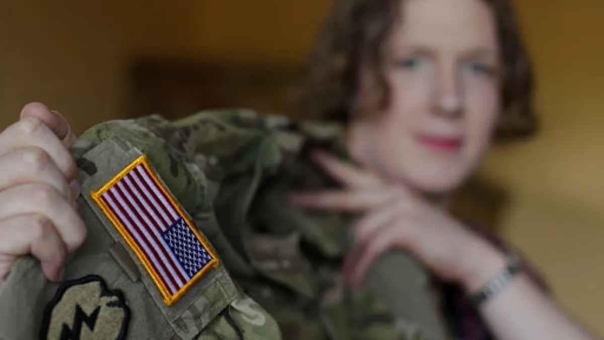 美國陸軍上尉希姆斯(Jennifer Sims )是跨性別者,她向美聯社記者秀出制服上的美國國旗(AP)