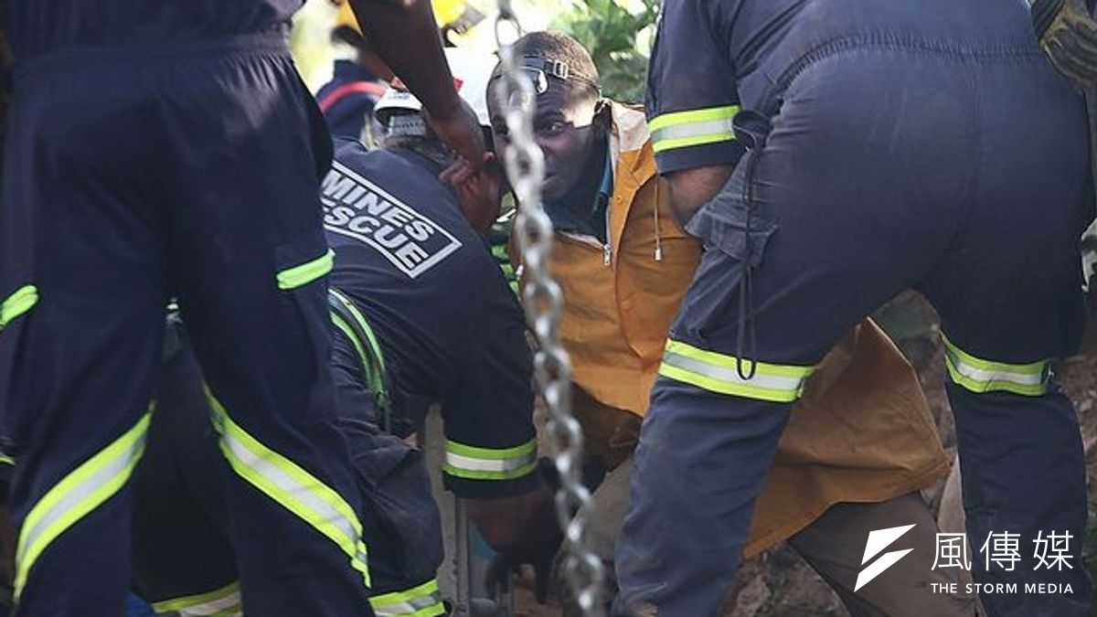 南非一處金礦崩塌,多名礦工受困,救難人員協助一名礦工脫臉。(美聯社) 南非一處金礦崩塌,多名礦工受困,救難人員協助一名礦工脫臉。(美聯社)
