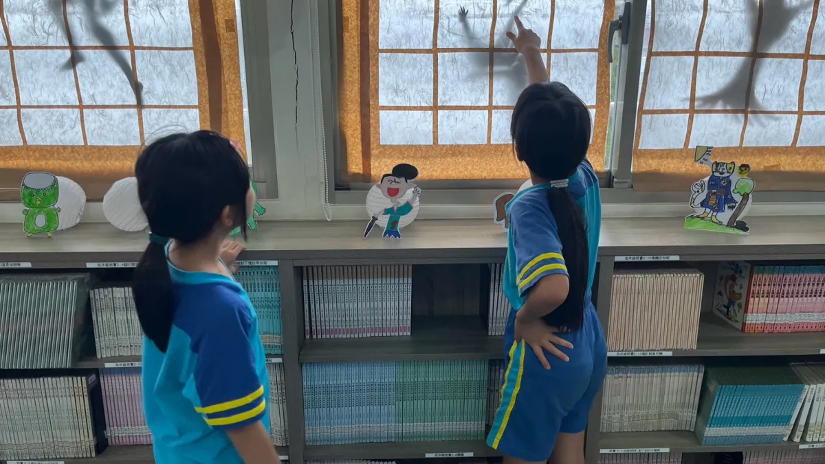 學生觀察窗上的妖怪剪影,探索圖書館內的主題布置。(圖/雨聲國小提供)