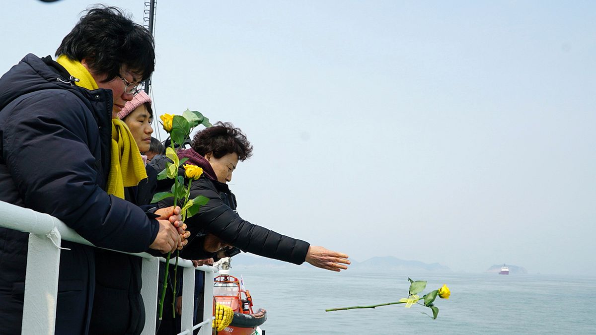 世越號失蹤者的家屬向大海投放悼念的花朵。(美聯社) 世越號失蹤者的家屬向大海投放悼念的花朵。(美聯社)