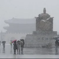On March 4, 2025, people walk past the statue of King Sejong outside Gwanghwamun Square in Seoul, South Korea, amid heavy snow. (AP) On March 4, 2025, people walk past the statue of King Sejong outside Gwanghwamun Square in Seoul, South Korea, amid heavy snow. (AP)