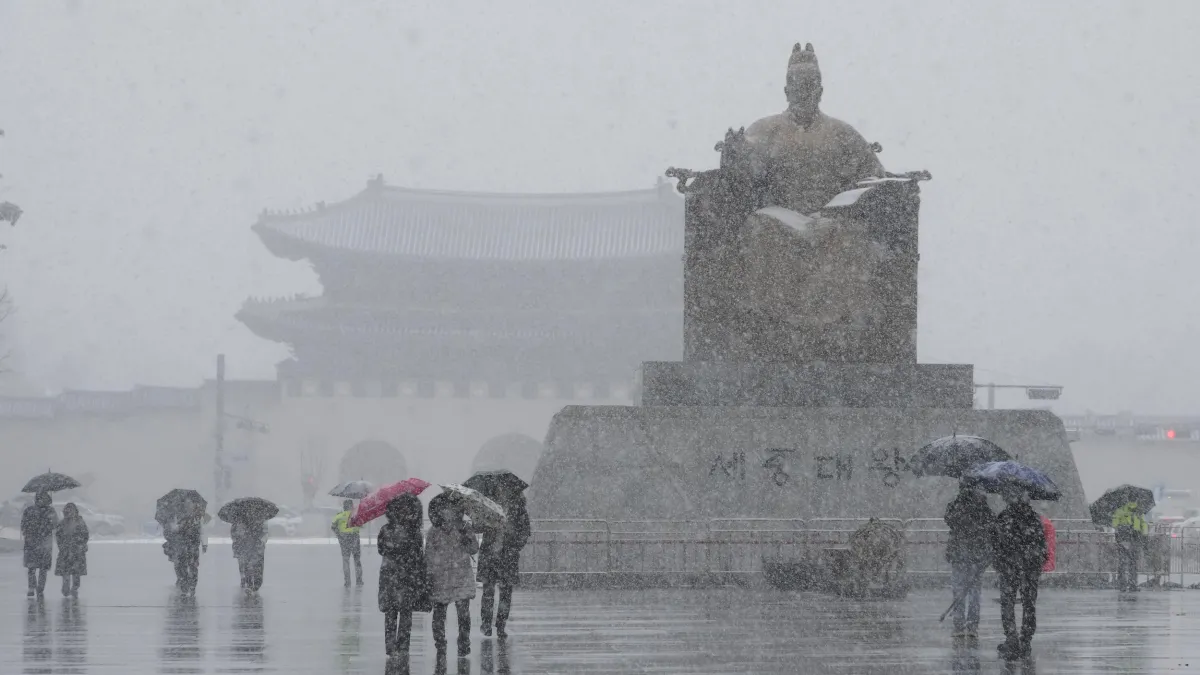 On March 4, 2025, people walk past the statue of King Sejong outside Gwanghwamun Square in Seoul, South Korea, amid heavy snow. (AP)