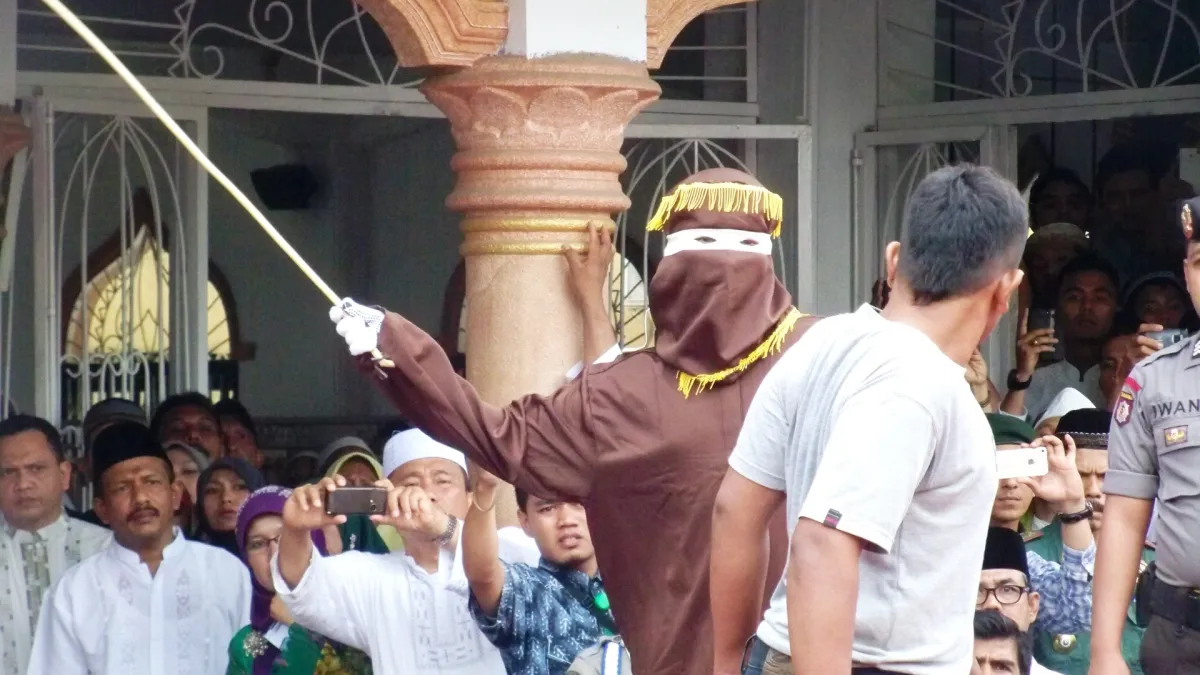 A convict receiving a caning sentence in Banda Aceh under sharia, September 19, 2014. (VOA)