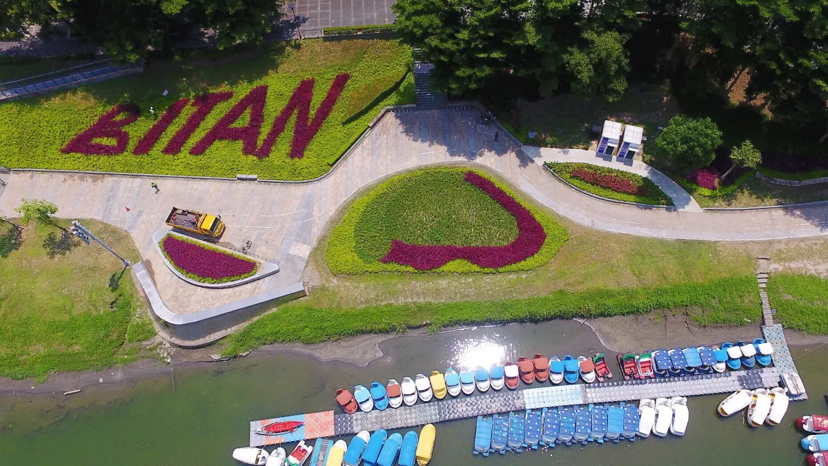 新北市府於水岸步道旁以亮眼色彩的植栽,寫下碧潭的英文名字「BITAN」。(圖/新北市綠美化環境景觀處提供)