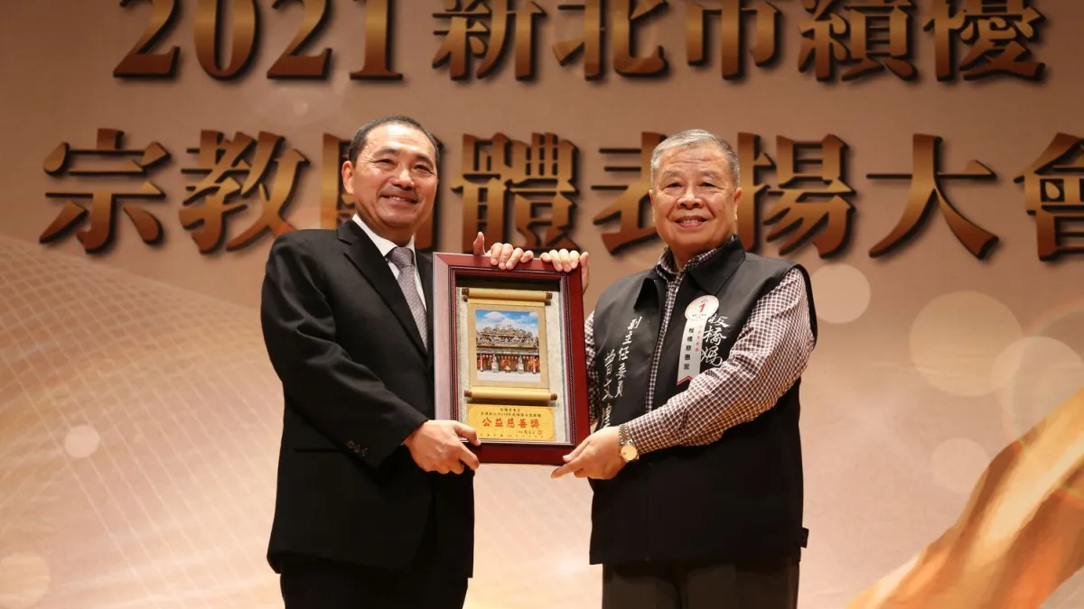 新北市長侯友宜頒發公益慈善獎由板橋慈惠宮副主任委員曾文煌代表受獎。(圖/新北市民政局提供)