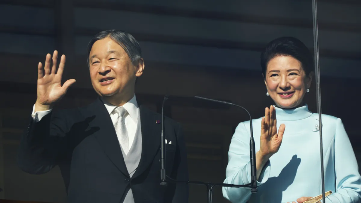 新年一般参賀で、集まった人々に手を振る天皇陛下(左)と皇后さま。(写真/AP通信)