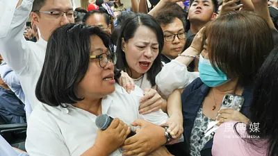 立法院內政委員會4日審查「公職人員選舉罷免法部分條文修正草案」,民進黨團一早便佔領主席台,民進黨立委王美惠(左)於過程中試圖將議事人員麥克風搶下。(顏麟宇攝)