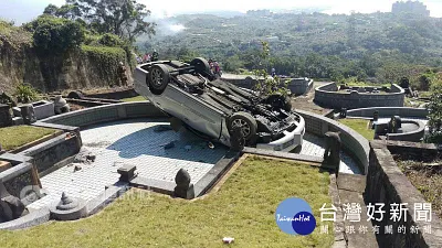轎車倒車失控 四輪朝天翻進墳墓