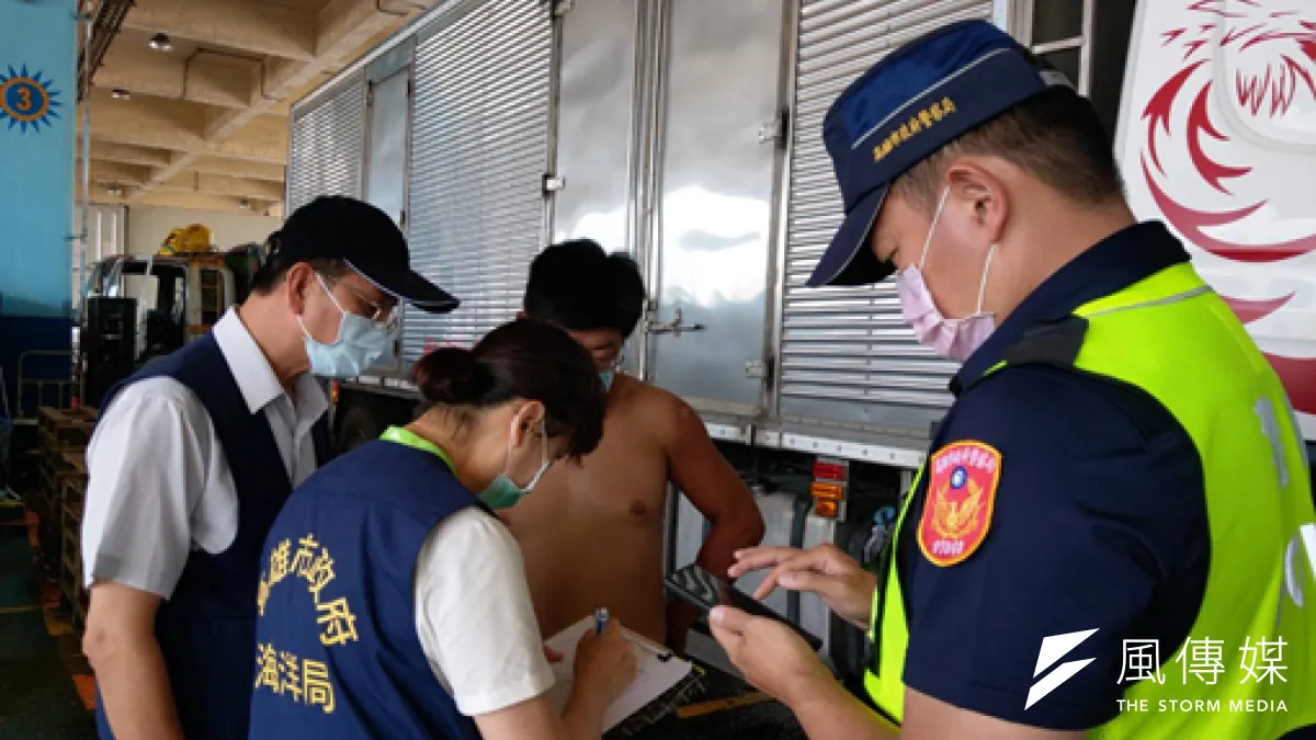 高雄市政府海洋局於前鎮魚市場對未配戴口罩民眾開舉發單。(圖/徐炳文攝)