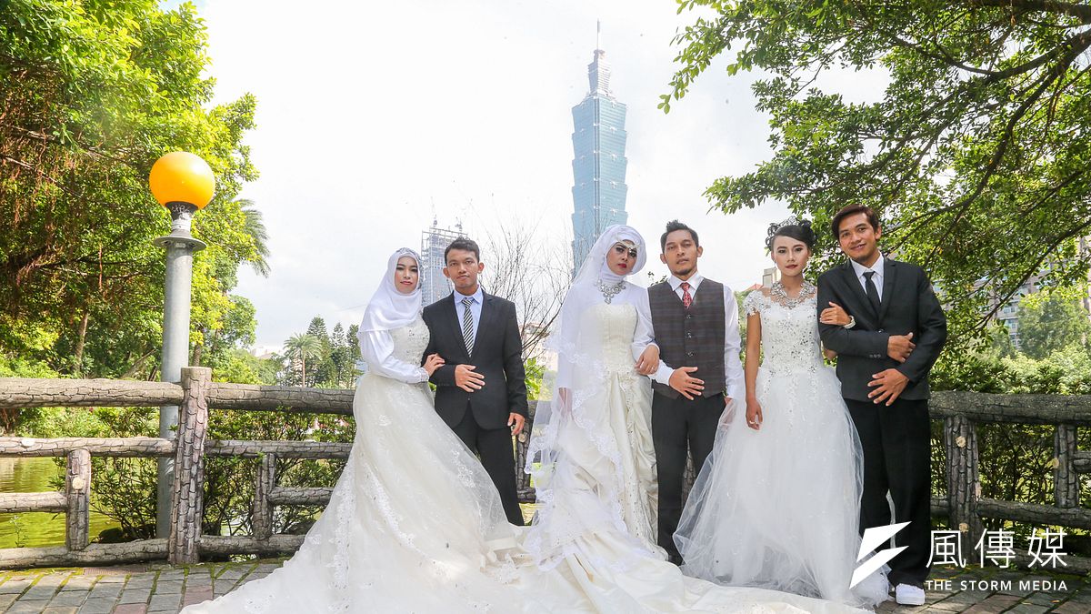 印尼代表處舉辦移工婚禮,於國父紀念館園區拍攝婚紗,3對新人以101為背景合影。(陳明仁攝) 印尼代表處舉辦移工婚禮,於國父紀念館園區拍攝婚紗,3對新人以101為背景合影。(陳明仁攝)