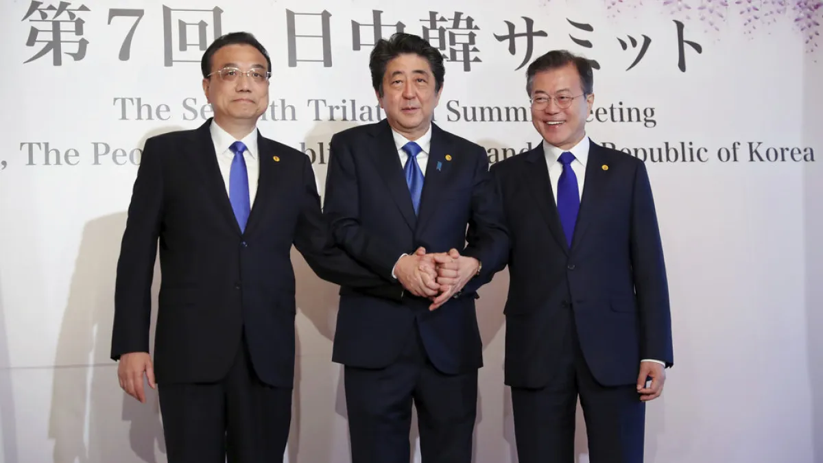 中日韓領導人會議9日在東京召開,安倍晉三、文在寅、李克強三人握手合影。(美聯社)
