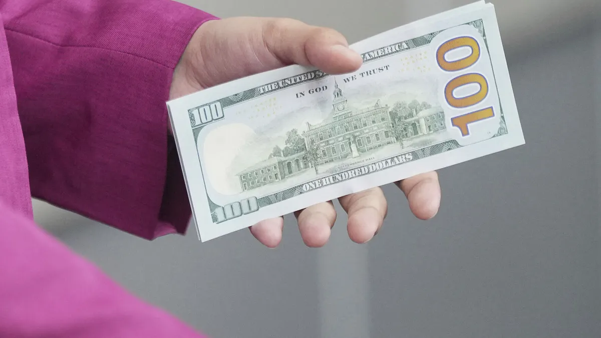 2025年4月8日。一名員工在印尼雅加達的一家貨幣兌換處拿著美元鈔票。(AP) 2025年4月8日。一名員工在印尼雅加達的一家貨幣兌換處拿著美元鈔票。(AP)