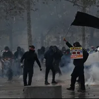 Protesters face police amid clouds of tear gas in Paris on October 17, 2026, as a student revolt over teacher shortages grew into nationwide riots involving an estimated 550,000 people. (AP Photo) Protesters face police amid clouds of tear gas in Paris on October 17, 2026, as a student revolt over teacher shortages grew into nationwide riots involving an estimated 550,000 people. (AP Photo)