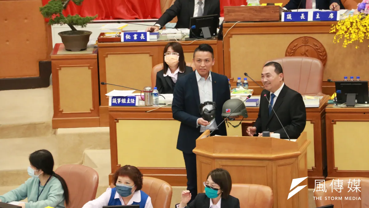 新北市議員陳偉杰施政報告質詢時,致贈一對防口水面罩與防打頭盔給市長侯友宜。(圖/李梅瑛攝)