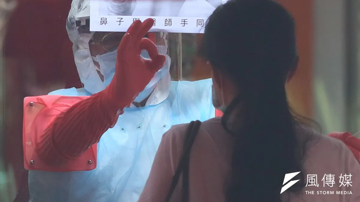 新北市政府在中和區積穗活動中心成立快篩站,一位執勤的醫護人員為民眾完成採檢後,做出OK的手勢。(柯承惠攝)