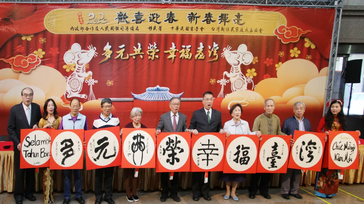 內政部長徐國勇(右五)、移民署長邱豐光(左一)與越南新住民陳秋柳(右一)、印尼新住民林達(左二)一起與書法名家揮毫寫春聯,並祝大家「新年快樂」。(圖/內政部移民署提供)