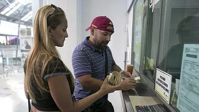 委內瑞拉民眾拿著大疊的玻利瓦紙鈔,在鄰國哥倫比亞邊境城市的商場裡換成哥倫比亞披索,準備購買民生用品(AP)