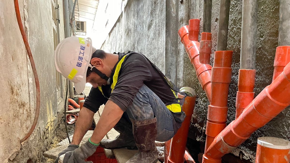 施工人員在後巷中進行污水接管,沒有人喜歡在又悶又臭的後巷或地底下工作,但我們知道撐過去就能讓整個環境變得更好。(圖/新北市水利局提供) 施工人員在後巷中進行污水接管,沒有人喜歡在又悶又臭的後巷或地底下工作,但我們知道撐過去就能讓整個環境變得更好。(圖/新北市水利局提供)