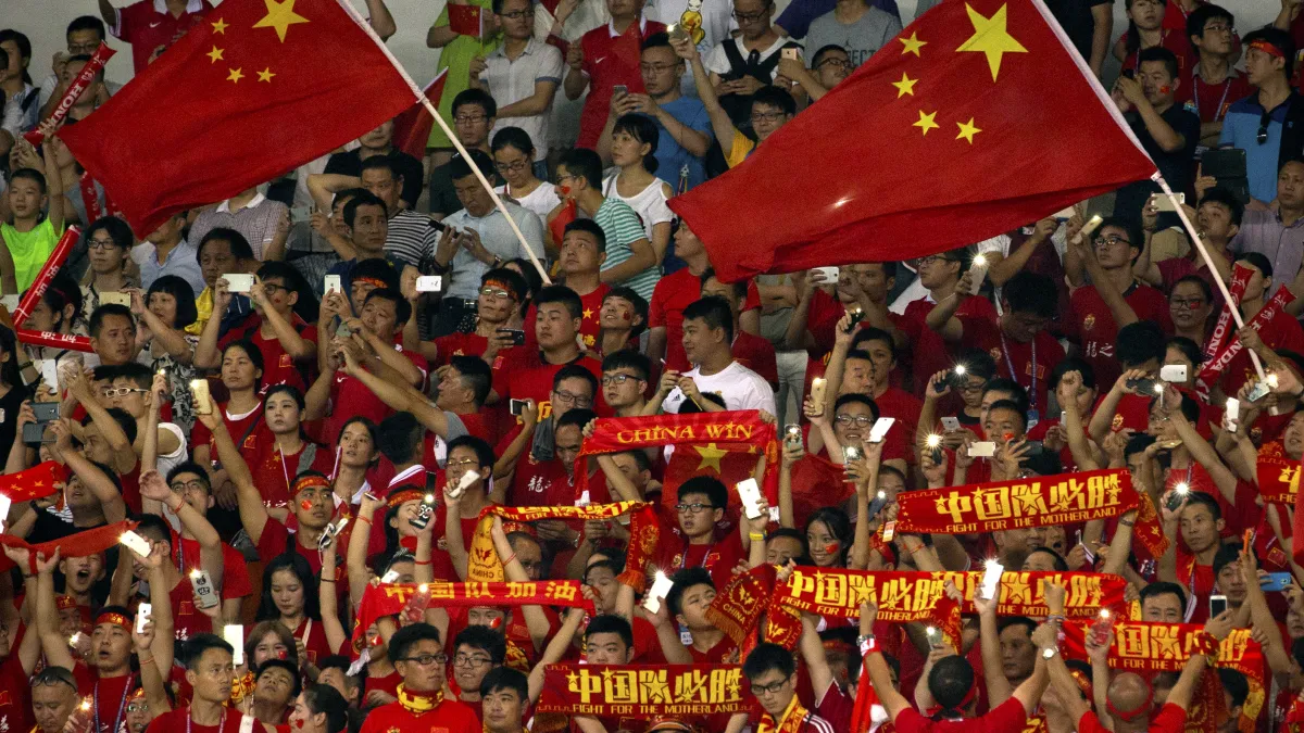 在運動競賽中揮舞國旗與標語的中國民眾。(美聯社)